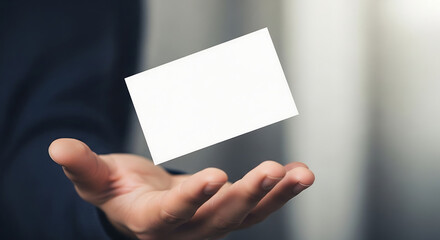 Hand presenting a blank white business card floating above the palm.