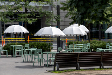 Public square with modern street furniture and sun umbrellas in downtown Montreal, Canada