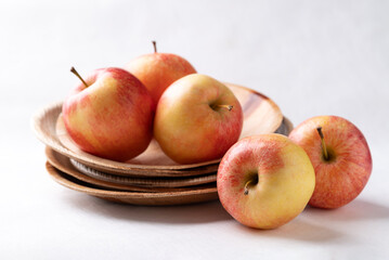 Red apple fruit (Gala apple) in natural plate on white background