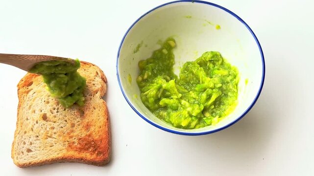 Mixing mashed avocado in a bowl and spreading mashed avocado on toast.