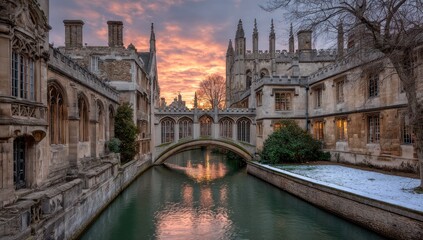 Obraz premium Historic stone buildings flank a river crossed by an ornate bridge under a colorful sunset