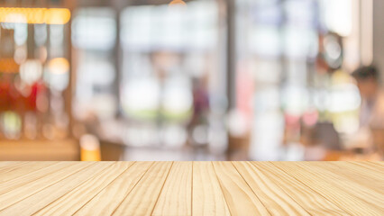 Obraz premium Empty wooden table top with blurred coffee shop interior background for product display mockup