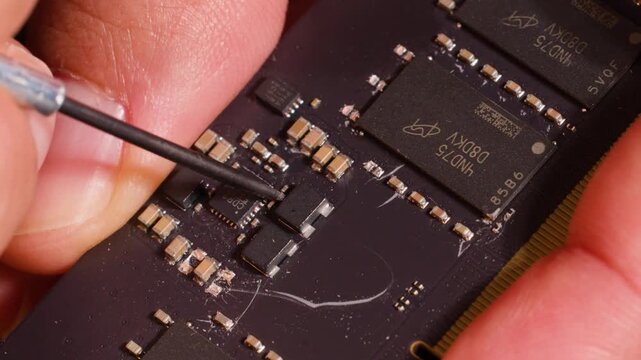 Macro View of Technician Repairing Computer RAM Module with Precision Tool