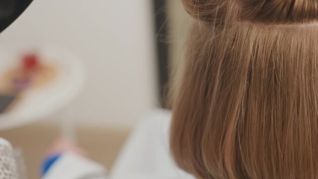 sleek bob smoothed and polished by stylist, final edge refined with comb and dryer to reveal glossy shine under studio lights, crisp blunt line and balanced silhouette, contemporary salon result