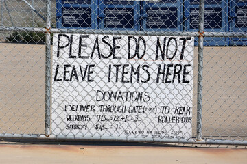 Please No Not Leave Donation Items Here sign attached to a chain link fence