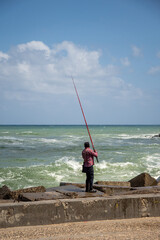 Fototapeta premium Man fishing from a jetty in Alexandria, Egypt