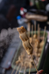 Steaming Korean fish cake skewers (Eomuk) boiling in a rectangular pot, winter outdoor camping vibes, warm broth, steam rising, delicious street food style.