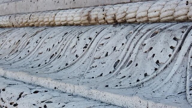 Slow motion close up showing detailed stone wall texture of Arc de Triomphe in Paris with carved lines, weathered surface, and historic craftsmanship