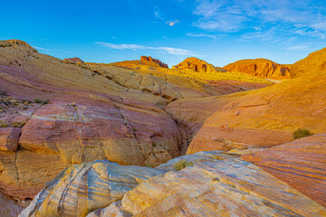 Wide sandstone basin surrounded by layered rock formations in the desert terrain of Valley of Fire State Park, Nevada.
