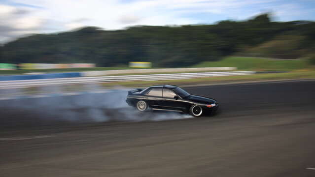 ドリフトする黒いセダン車