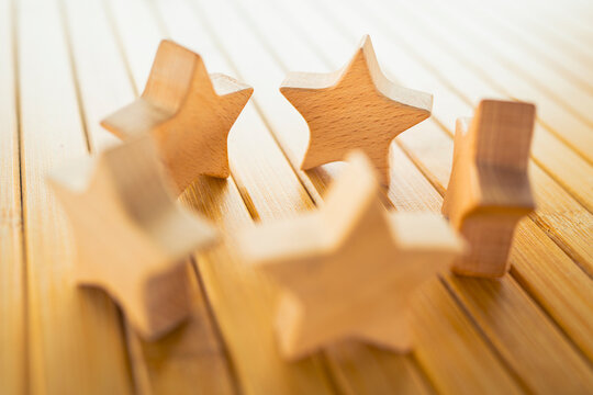 Wooden star figures arranged on table representing customer rating, product review, service quality evaluation, satisfaction measurement, business feedback and brand reputation concept.