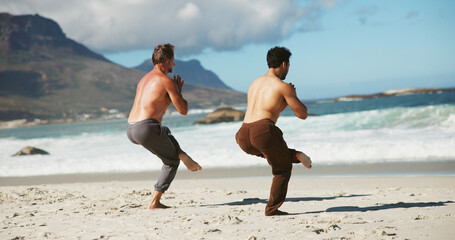 Fitness, coach or men at beach with yoga, guidance and balance in wellness activity. Exercise, eagle pose or people at ocean with instructor, zen and mobility improvement in holistic practice.