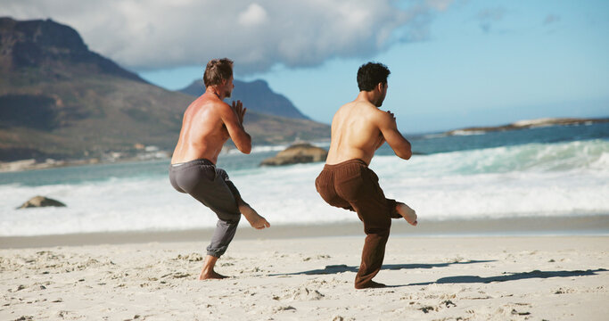 Fitness, coach or men at beach with yoga, guidance and balance in wellness activity. Exercise, eagle pose or people at ocean with instructor, zen and mobility improvement in holistic practice.