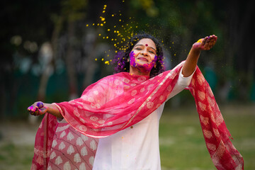 young indian woman playing colors on traditional festival holi