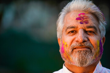 indian senior man celebrating holi festival