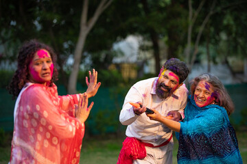 Fototapeta premium Happy indian people playing colors while celebrating holi festival