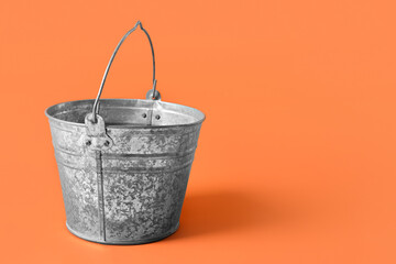 Galvanized bucket on orange background
