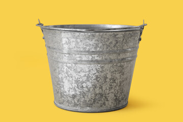 Galvanized metal bucket on yellow background
