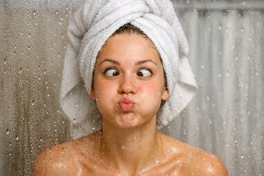 Playful Woman Makes a Funny Face in Shower After Bathing Time.