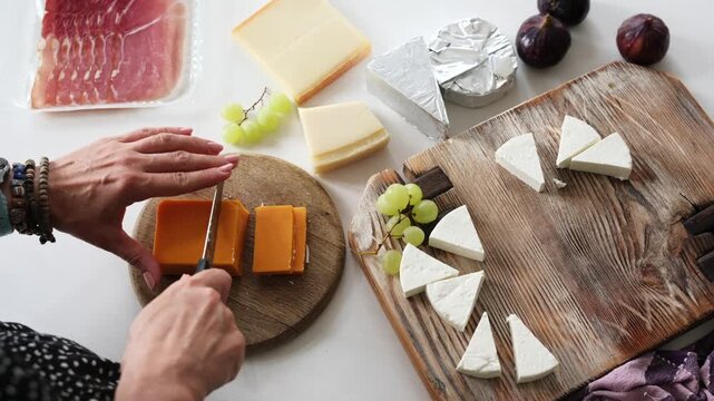 Girl Cuts Cheddar Cheese On A Board For A Cheese Plate