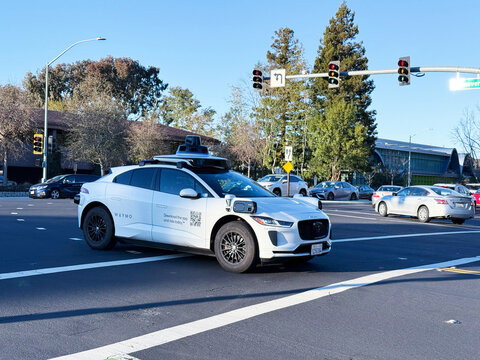 Waymo autonomous Jaguar I-PACE electric vehicle navigates multi-lane Silicon Valley intersection - Palo Alto, California, USA - January 14, 2026