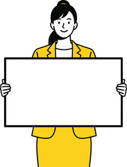 Professional businesswoman in a yellow suit with a hair bun smiling while holding a blank white board.