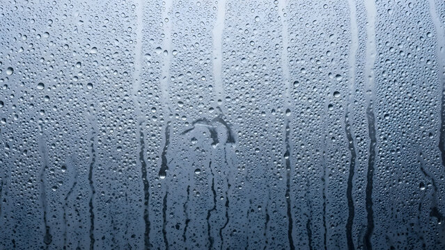Heavy condensation water drops on a steamy window glass