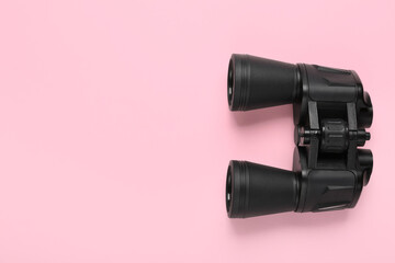 Modern binoculars on pink background