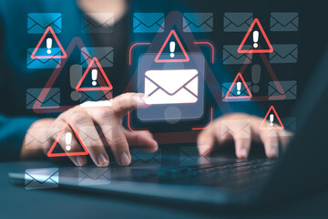 Email security software detecting phishing or scam emails with warning alerts, as a businessperson touches the email icon to delete malicious messages and protect sensitive data.