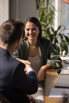 Happy Hispanic business professional woman shaking hands with legal consultant, advisor, thanking for expertise, smiling. Positive job candidate getting hired, giving handshake to employer