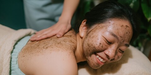 Naklejka premium Asian young woman enjoying a relaxing back massage and mud clay mask treatment at a beauty spa for skin care and wellness with copy space