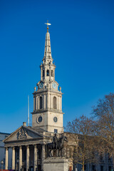 St Martin-in-the-Fields church with clock tower against blue sky, London