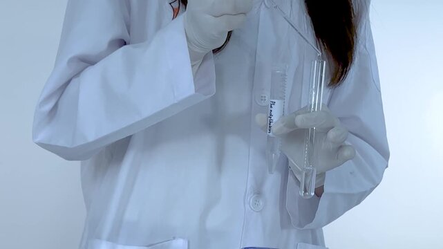 Scientist Adding Liquid to Test Tube Causing Pink Color Change