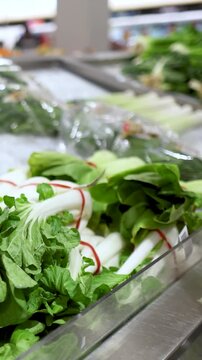 Close Up of Hand Selecting Fresh Bok Choy in Supermarket