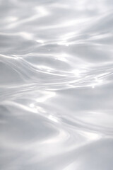 Obraz premium Close-up of shimmering white water surface with gentle ripples and light reflections.