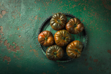 Large black tomato on a green vintage background