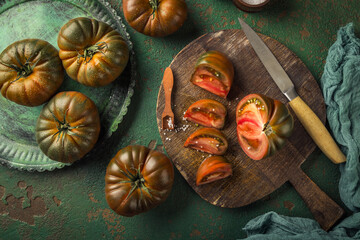 Large black tomato on a green vintage background