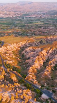 Vertical video. Goreme, Nevsehir, Turkey. Sunset panoramic view of Devrent Valley and surrounding areas with dramatic lighting on unique geological formations.. Aerial View. Rich colors