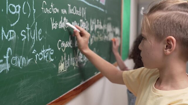 Diverse student studying coding engineering prompt while writing answer on blackboard. Intelligence children planning and learning about coding development plan. Successful boy sharing idea. Pedagogy.
