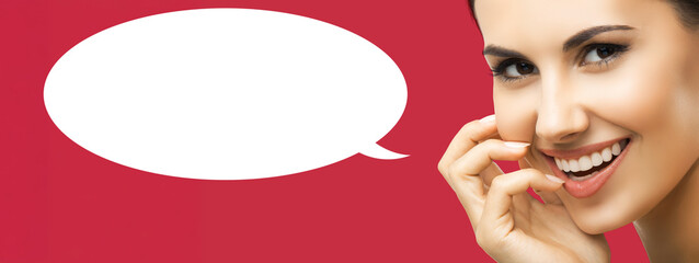 Face portrait of expressive happy cute young woman, isolated red background. Brunette hair brightly teeth smiling girl. Dental care, dent concept. White mockup speech bubble with free ad text space