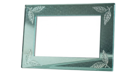 Decorative Glass Frame: A transparent glass frame, adorned with leaf engravings, sits empty, reflecting a delicate interplay of light.