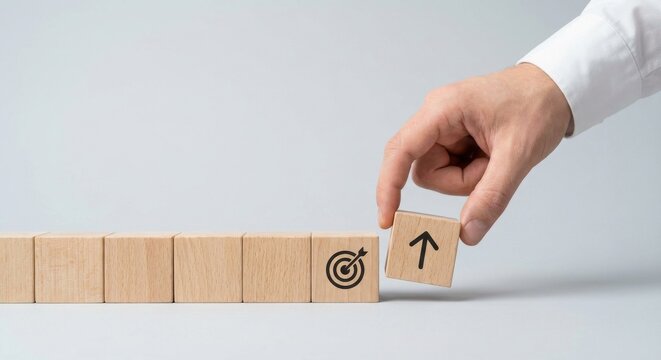 Hand placing wooden block with up arrow next to target icon, symbolizing business growth, sales increase, and exceeding goals. Conceptual design for corporate strategy, financial rising, and success m