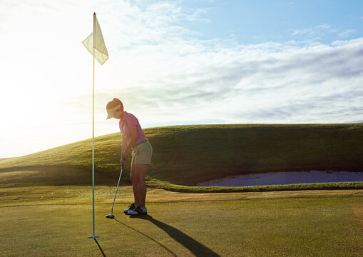 Woman, play and aim with flagstick on golf course for game, practice session and green fairway. Space, female person and shot for target of match, golfer technique and recreational sports outdoor