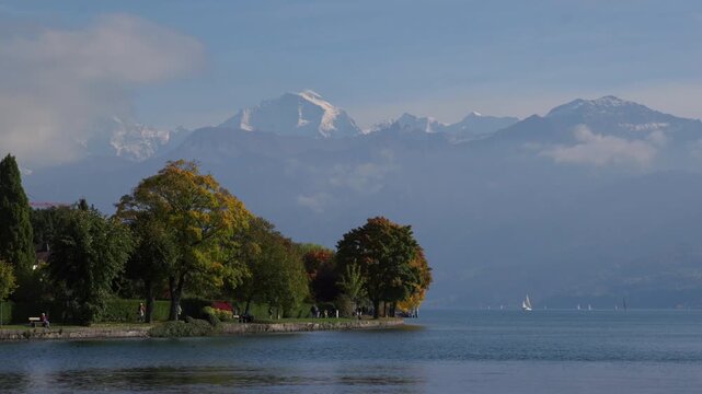 Swiss Alps Grindelwald Jungfrau mountains Bernese Oberland Thunersee Lake Thun aerial drone Thun Switzerland Schweiz Fall Autumn sunny morning low clouds haze Interlaken Sailboats walking path static