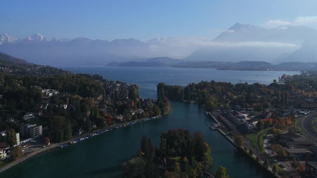 Swiss Alps Grindelwald Jungfrau mountains Bernese Oberland Thunersee Lake Thun Flusswelle Aare River aerial drone Thun Switzerland Schweiz Fall Autumn sunny morning clouds Interlaken circle right