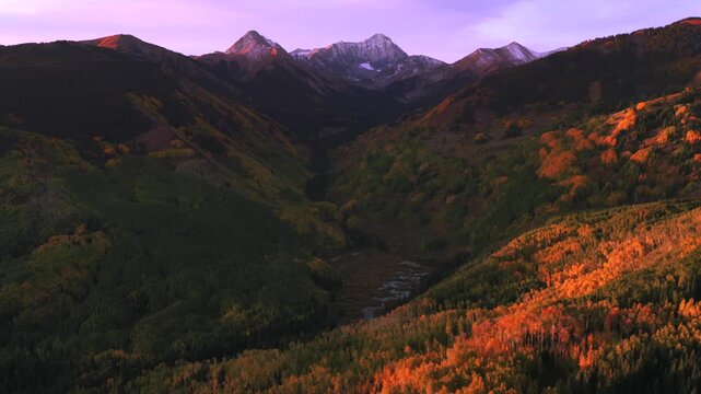 Morning Sunrise Alpenglow first light Capitol Peak 14er Autumn Fall Aspen Snowmass Colorado aerial drone colorful aspen trees grove White River Forest Elk Range Rocky Mountains backwards pan up motion