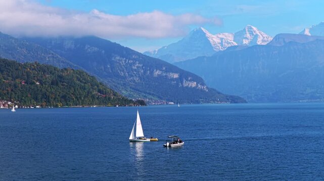 Sailboat Swiss Alps Grindelwald Jungfrau mountains Bernese Oberland Thunersee Lake Thun aerial drone Thun Switzerland Schweiz Fall Autumn sunny morning low clouds haze Interlaken circle left motion