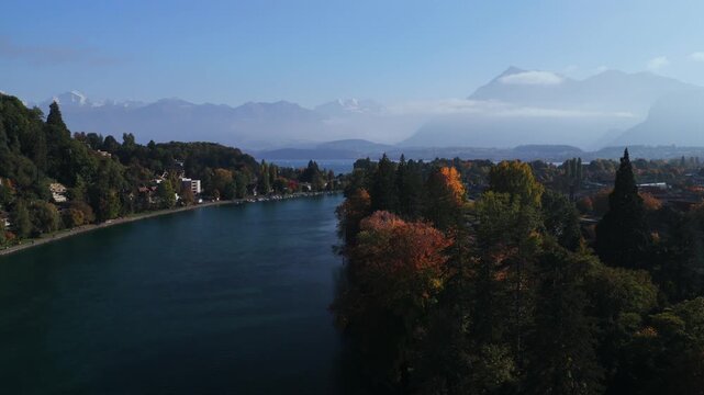 Swiss Alps Grindelwald Jungfrau mountains Bernese Oberland Thunersee Lake Thun Flusswelle Aare River aerial drone Thun Switzerland Schweiz Fall Autumn sunny morning clouds Interlaken upwards motion