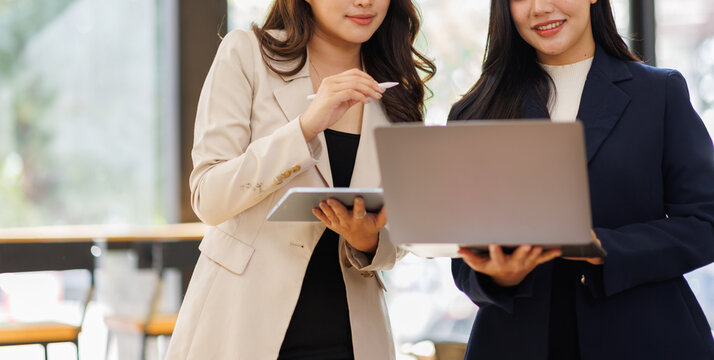 Team of asian women sharing a joyful moment in the office. Professional team laughing and enjoying each other's company. Colleagues bonding and connecting during a casual meeting.
