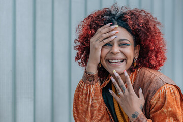 black woman smiling out loud in the street outdoors